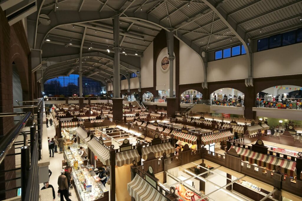 pexels photo 13276049 Explore the bustling indoor market hall in Kharkiv, Ukraine, showcasing various stalls under a vast arched ceiling.