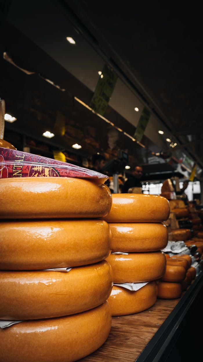 Stacks of Gouda cheese wheels on a market table in Maastricht, Netherlands.